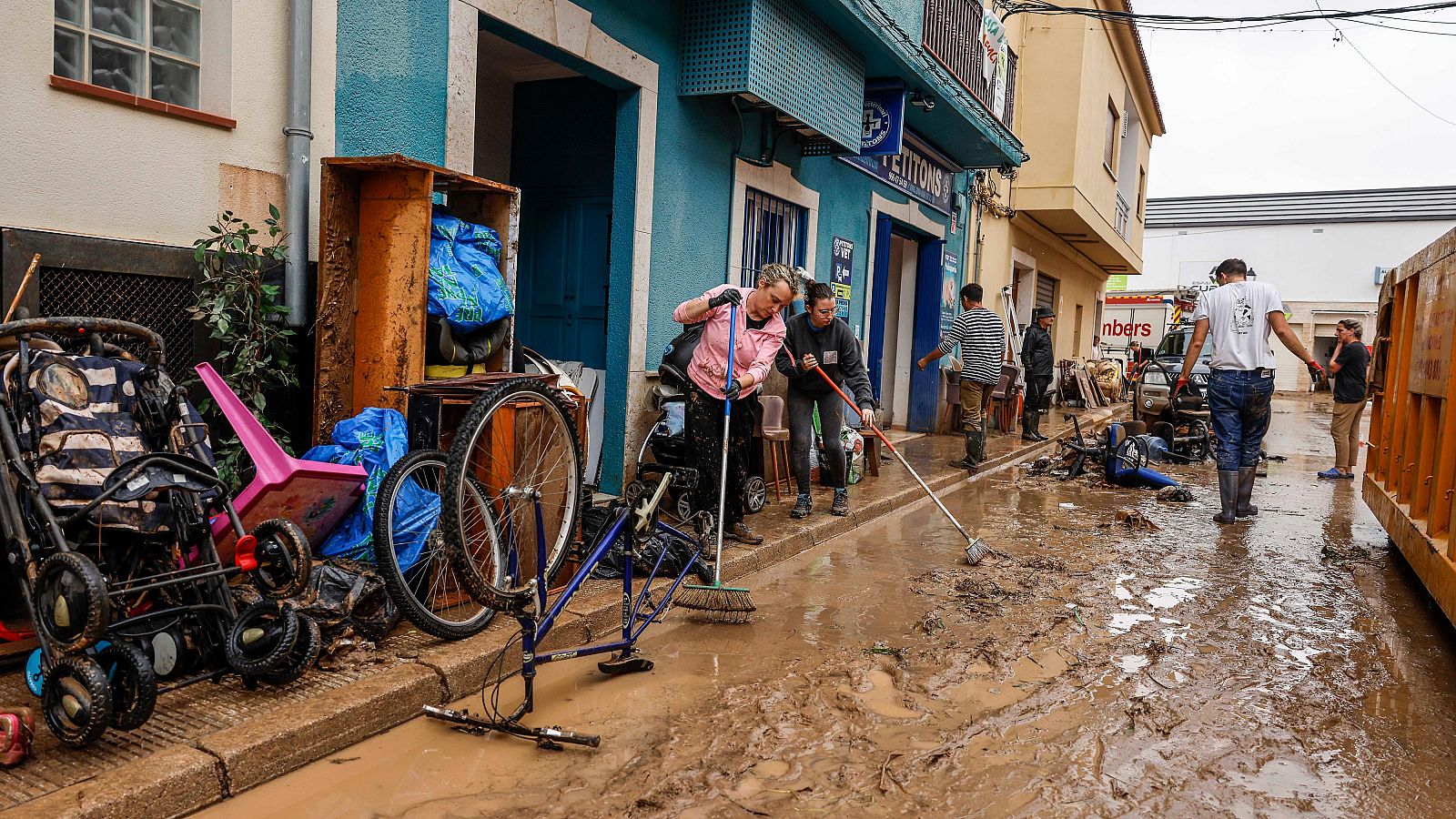 Un grupo de vecinos limpia las calles tras las fuertes lluvias en Els Poblets, Comunidad Valenciana