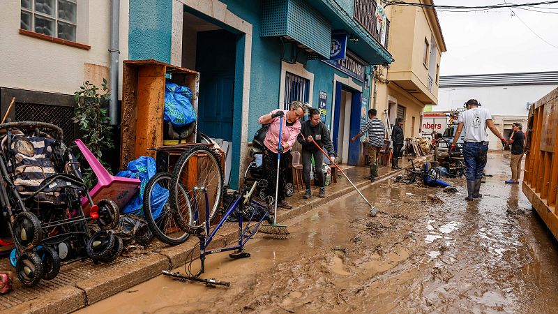 Un grupo de vecinos limpia las calles tras las fuertes lluvias en Els Poblets, Comunidad Valenciana