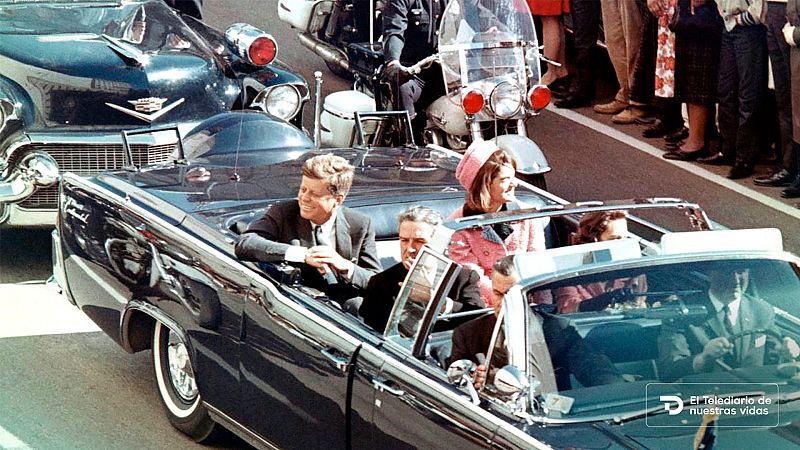 Caravana presidencial de John F. Kennedy en Dallas en 1963, con la limusina, agentes de seguridad y espectadores.