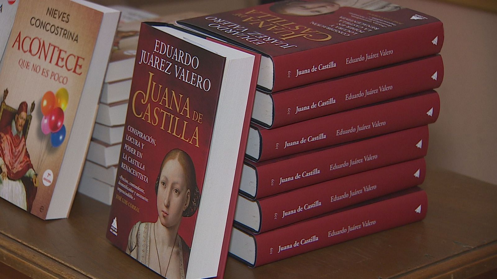 Selección de libros sobre superficie de madera, destacando en el centro la obra 'Juana de Castilla' de Eduardo Juárez Valero junto a otros ejemplares.