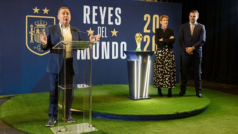 Rafa del Amo interviene ante un atril junto al trofeo de la Copa del Mundo y la presidenta de Navarra, María Chivite, frente a un panel azul con el lema Reyes del Mundo.