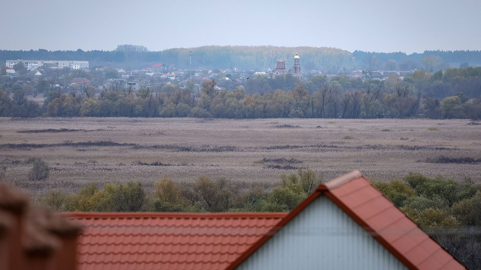Vista general de la ciudad ucraniana de Oleshki bajo un cielo encapotado en noviembre de 2022, mostrando el perfil urbano con una iglesia ortodoxa y la llanura circundante.