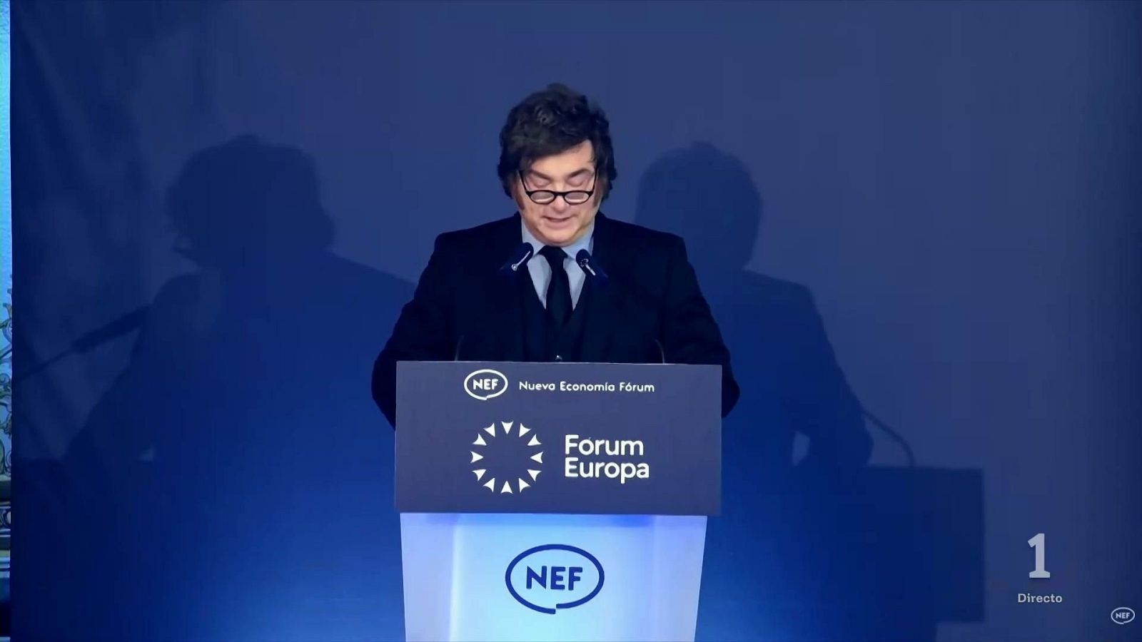 Javier Milei interviene leyendo un discurso tras un atril con el logotipo de Nueva Economía Fórum durante una emisión de Televisión Española.