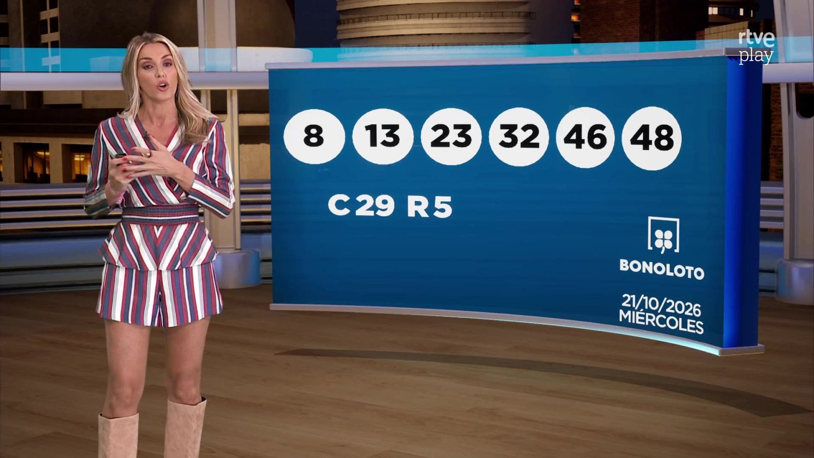 La presentadora Sandra Daviú en el plató de Loterías y Apuestas del Estado junto a un panel con los resultados de la Bonoloto del 21 de octubre de 2020.