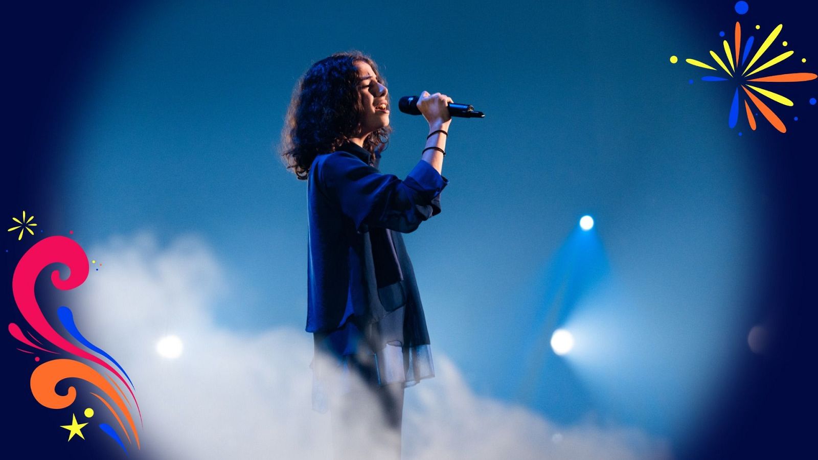 Joven artista de perfil cantando con un micrófono en un escenario con humo e iluminación azul, decorado con gráficos de estrellas y espirales.