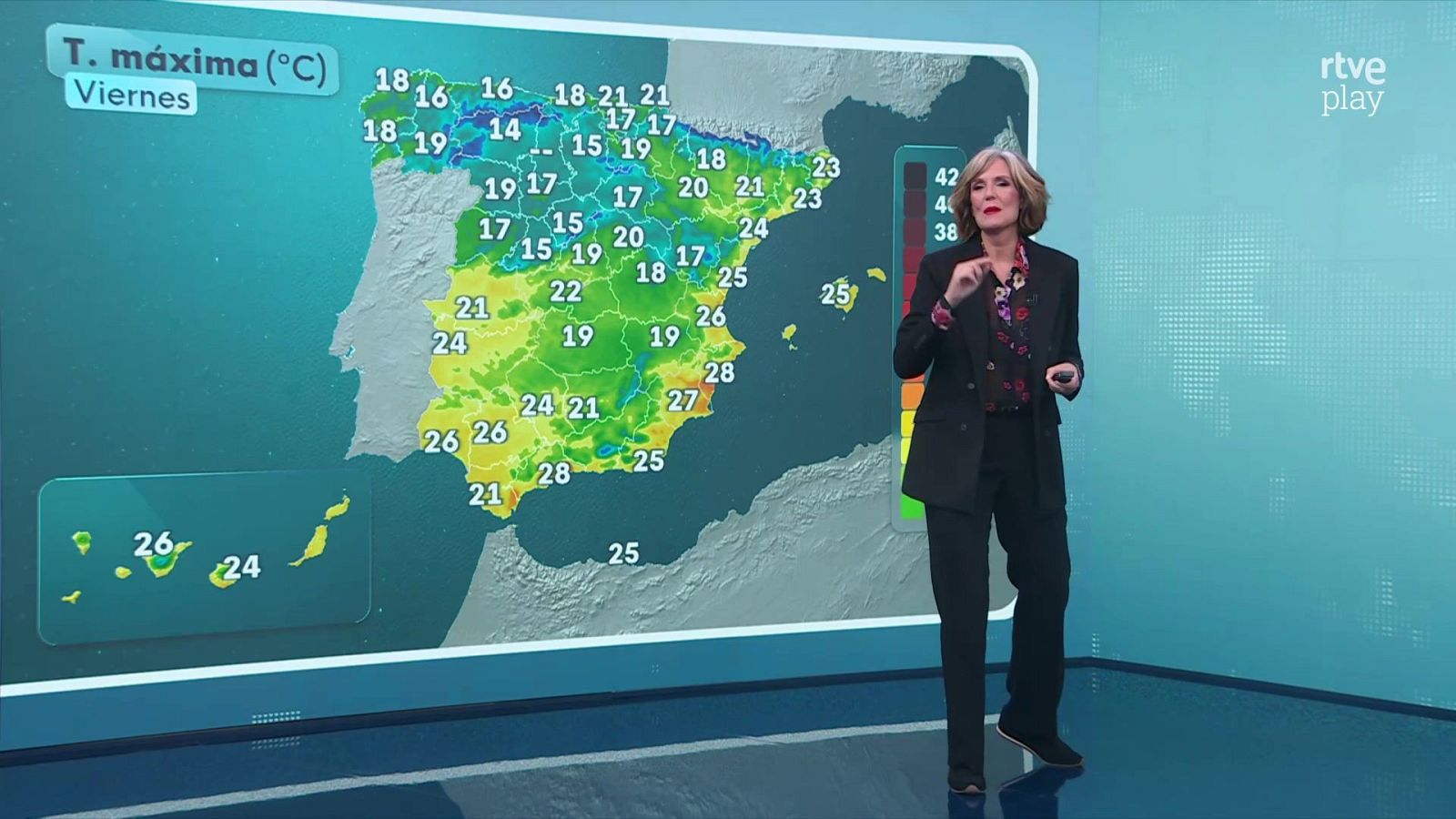 Una presentadora en un plató de televisión explica la predicción meteorológica de temperaturas máximas en España apoyada en un mapa interactivo.