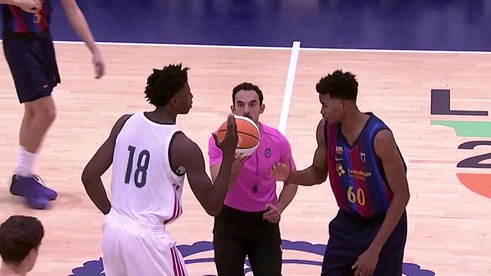 Un árbitro en el centro de la pista sostiene el balón entre dos jugadores concentrados listos para el salto inicial.
