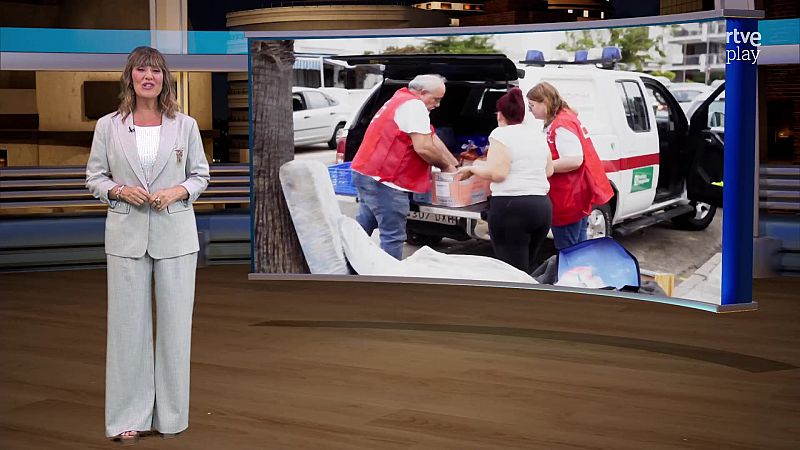 La presentadora Marta Jaumandreu conduce un informativo en un plató con una gran pantalla que muestra ayuda humanitaria.
