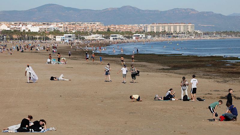 Varias personas disfrutan en la playa de las Arenas, de las agradables temperaturas que se registran este domingo en Valencia