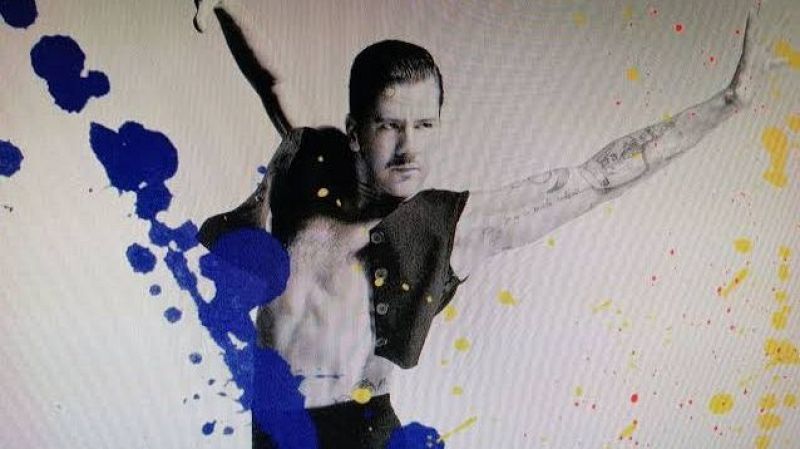 El bailaor José Maldonado posa dinámicamente en blanco y negro, rodeado de coloridas salpicaduras de pintura azul, amarilla y roja.