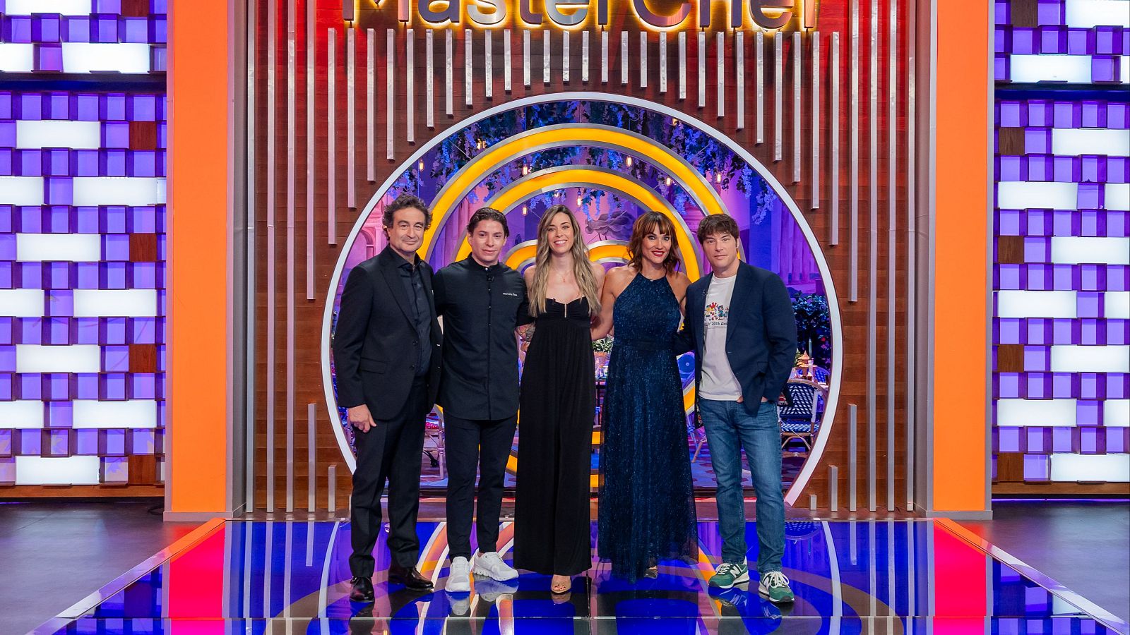 Cinco personas posan sonrientes en el plató de MasterChef, incluyendo a los chefs Pepe Rodríguez y Jordi Cruz junto a la periodista Irene Villa.