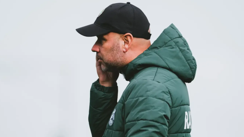 José Alberto López, entrenador de fútbol, viste anorak verde con escudo del club y gorra negra en un entrenamiento.