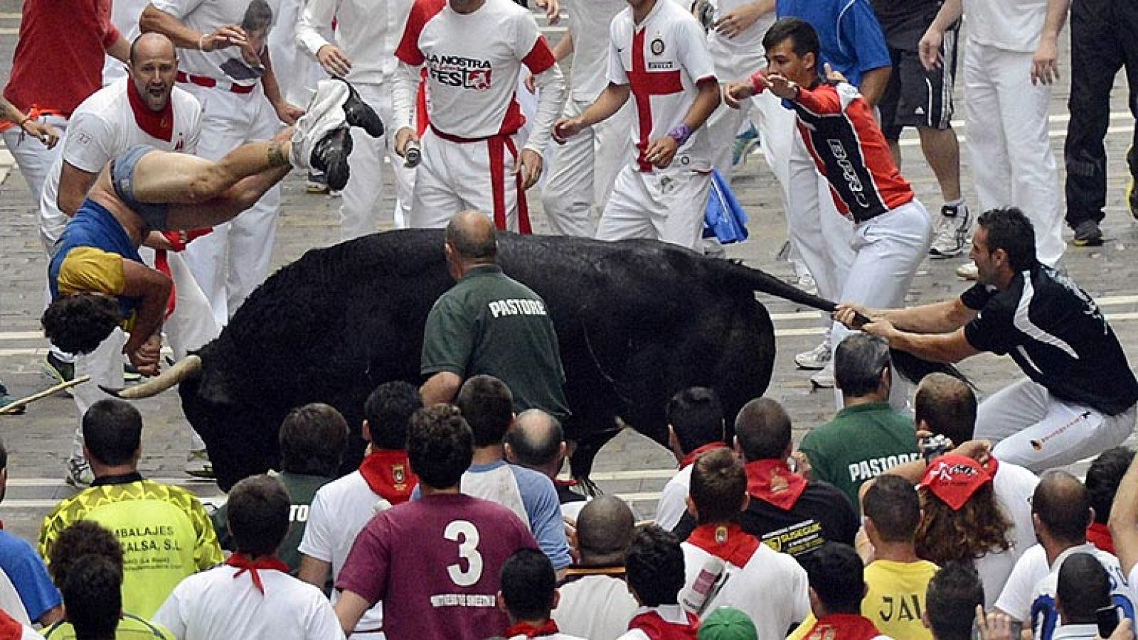 Pastores y corredores auxilian al mozo corneado en Estafeta en el sexto encierro de San Fermín 2013
