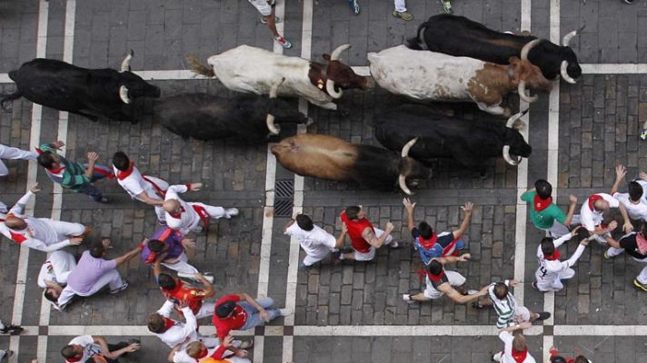 San Fermín - Un mozo con gorra se "cuela" entre dos astados