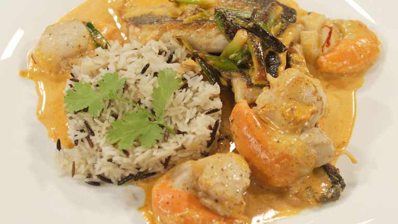 Lubina, ajetes y vieiras con salsa de azafrán y curry