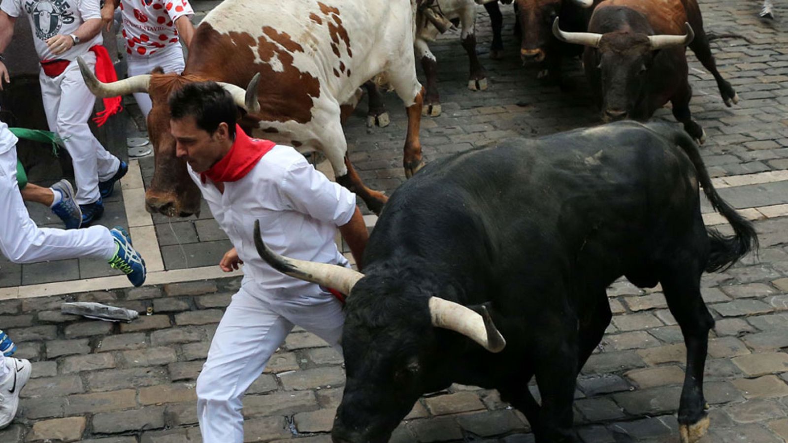 Los mozos corren en los laterales de la manada en el segundo encierro de San Fermín