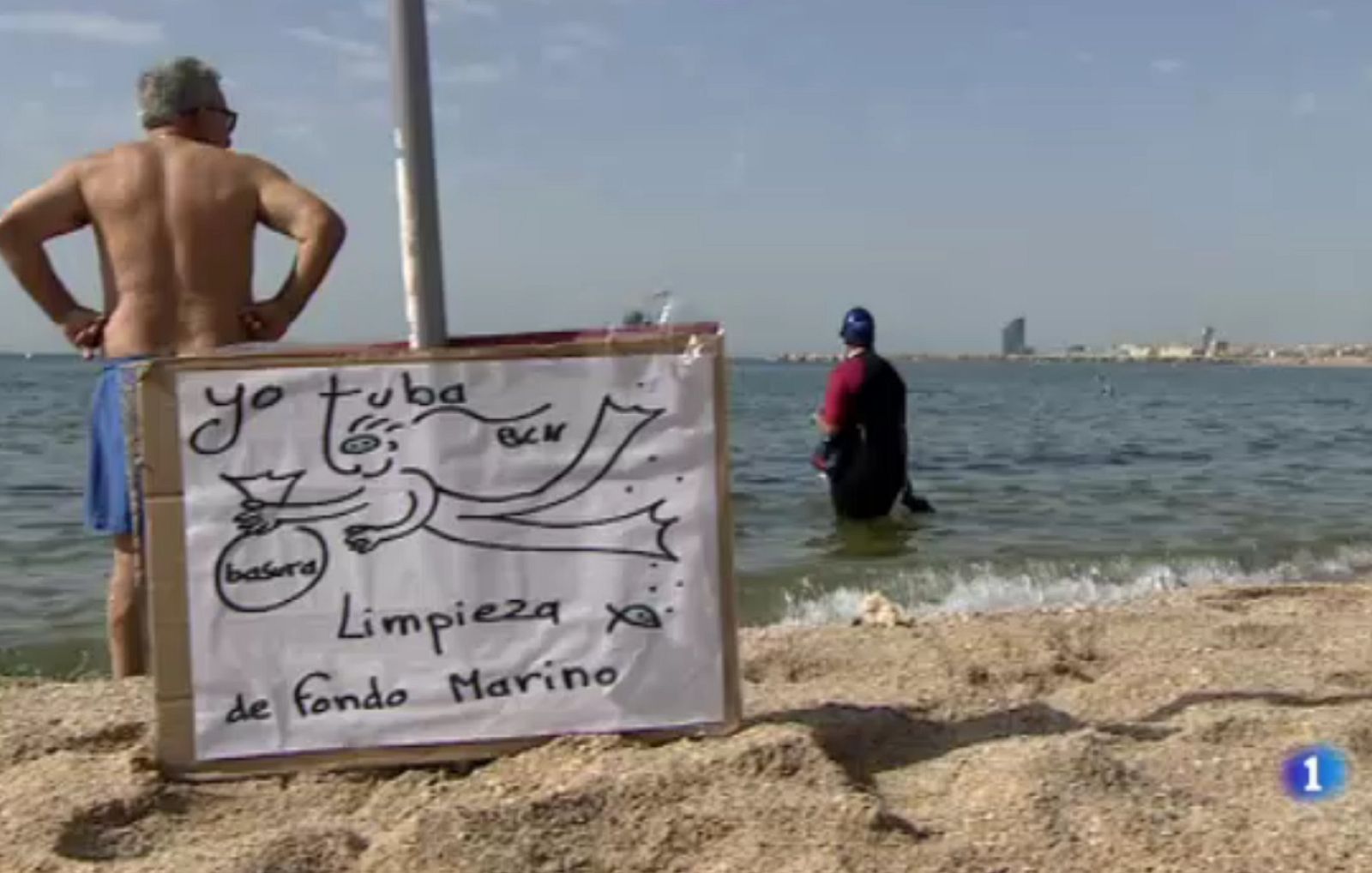 Un grup de bussejadors i nedadors participen en la neteja de la platja de la Mar Bella de Barcelona