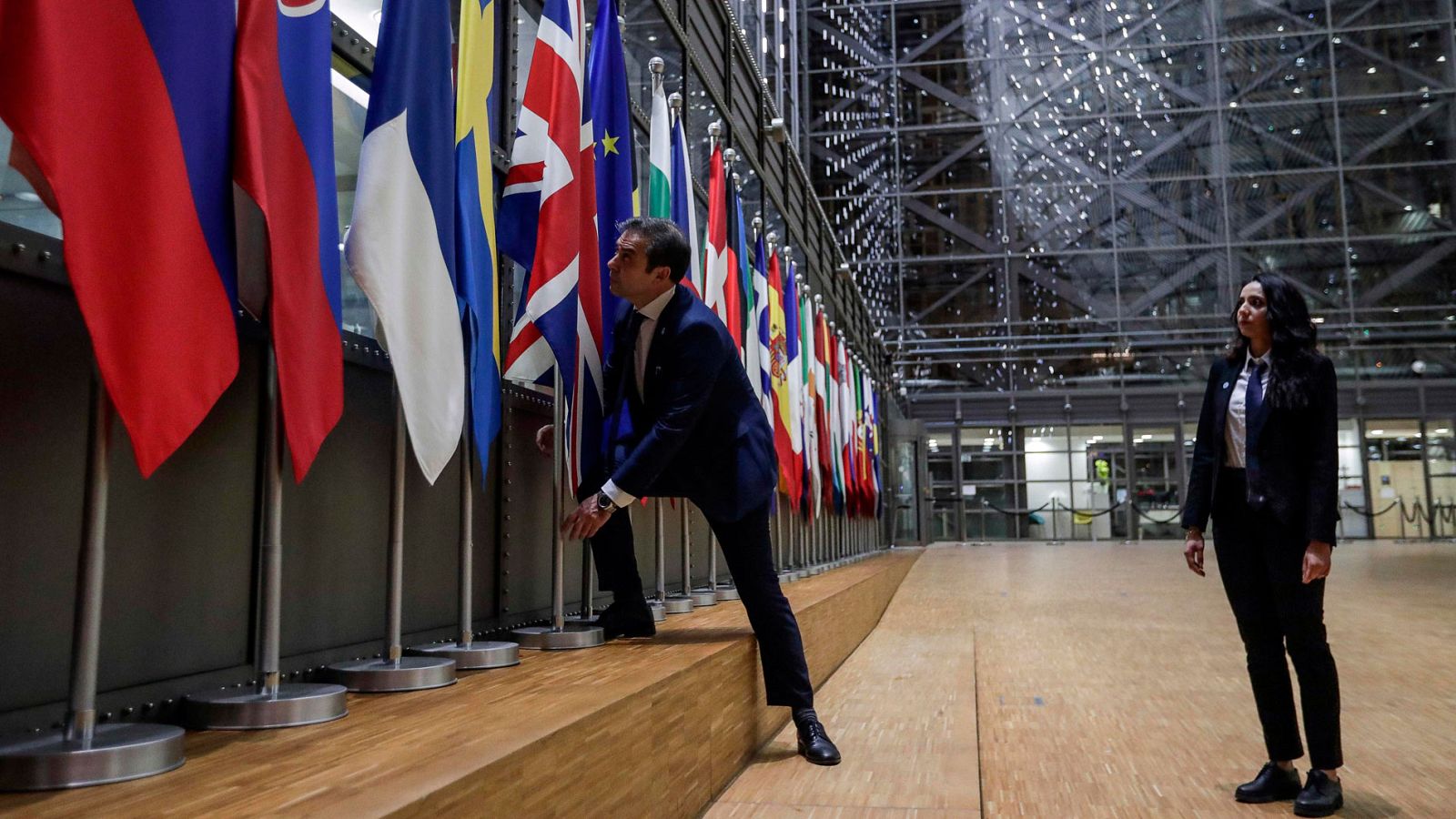 Dos funcionarios retiran la bandera del Reino Unido de la sede de la Comisión Europea en Bruselas