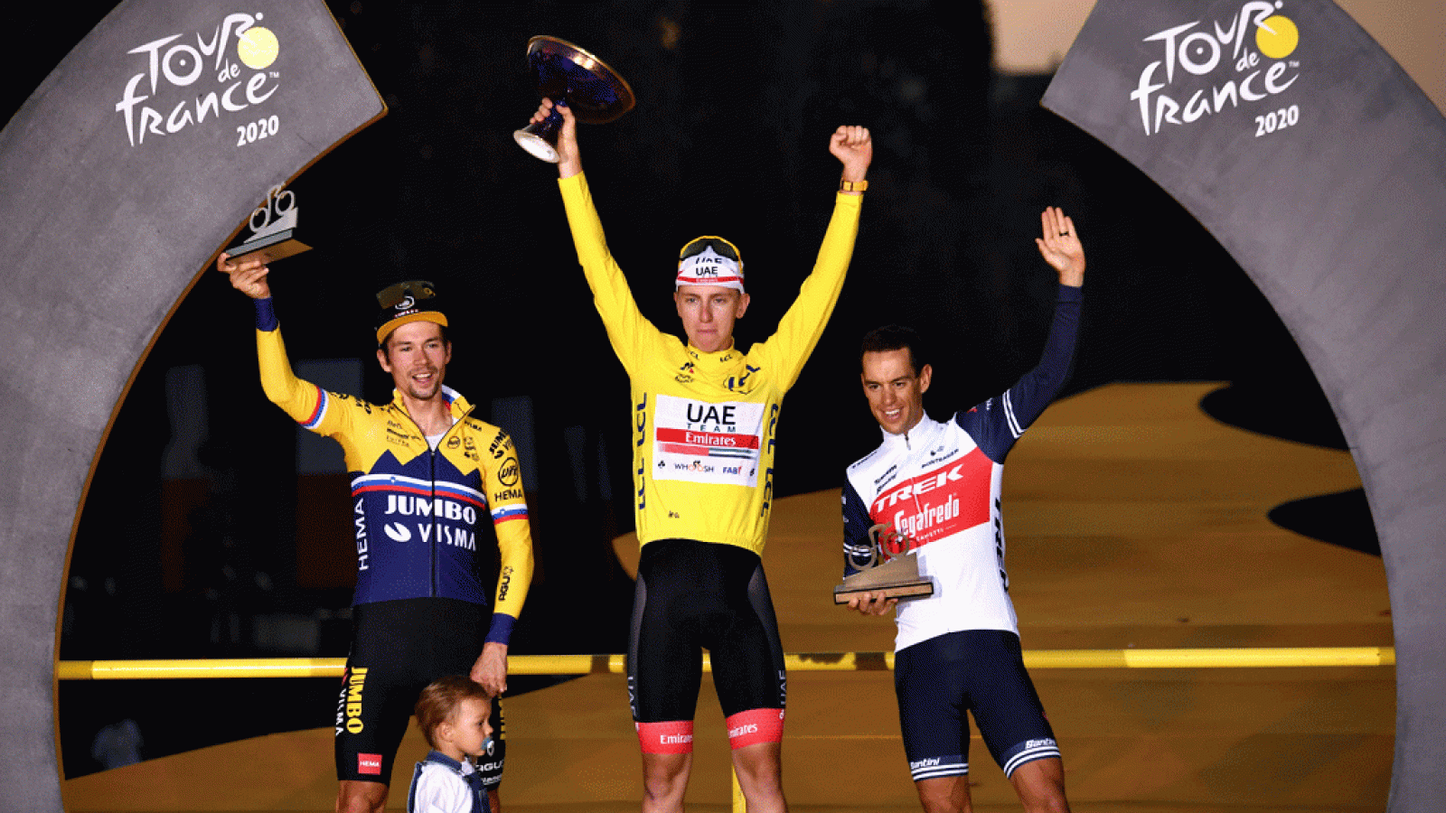 Tadej Pogacar escoltado en el podio por Roglic y Porte