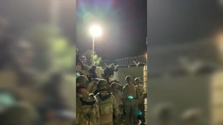  - Militares españoles ayudan a afganos a entrar en el aeropuerto de Kabul