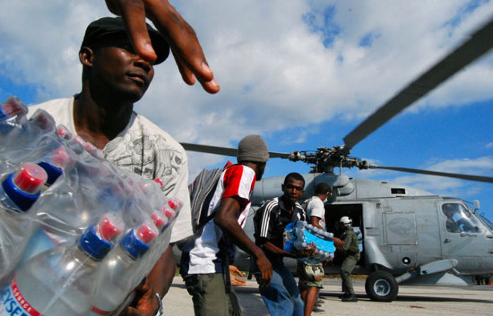 El aeropuerto se ha convertido en un putno de atención donde los haitianos se concentran a diario en busca de trabajo o ayuda humanitaria (21/01/2010).
