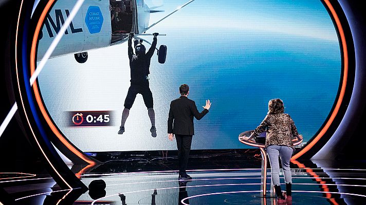  - El hombre pájaro sujeto de una barra aguanta suspendido