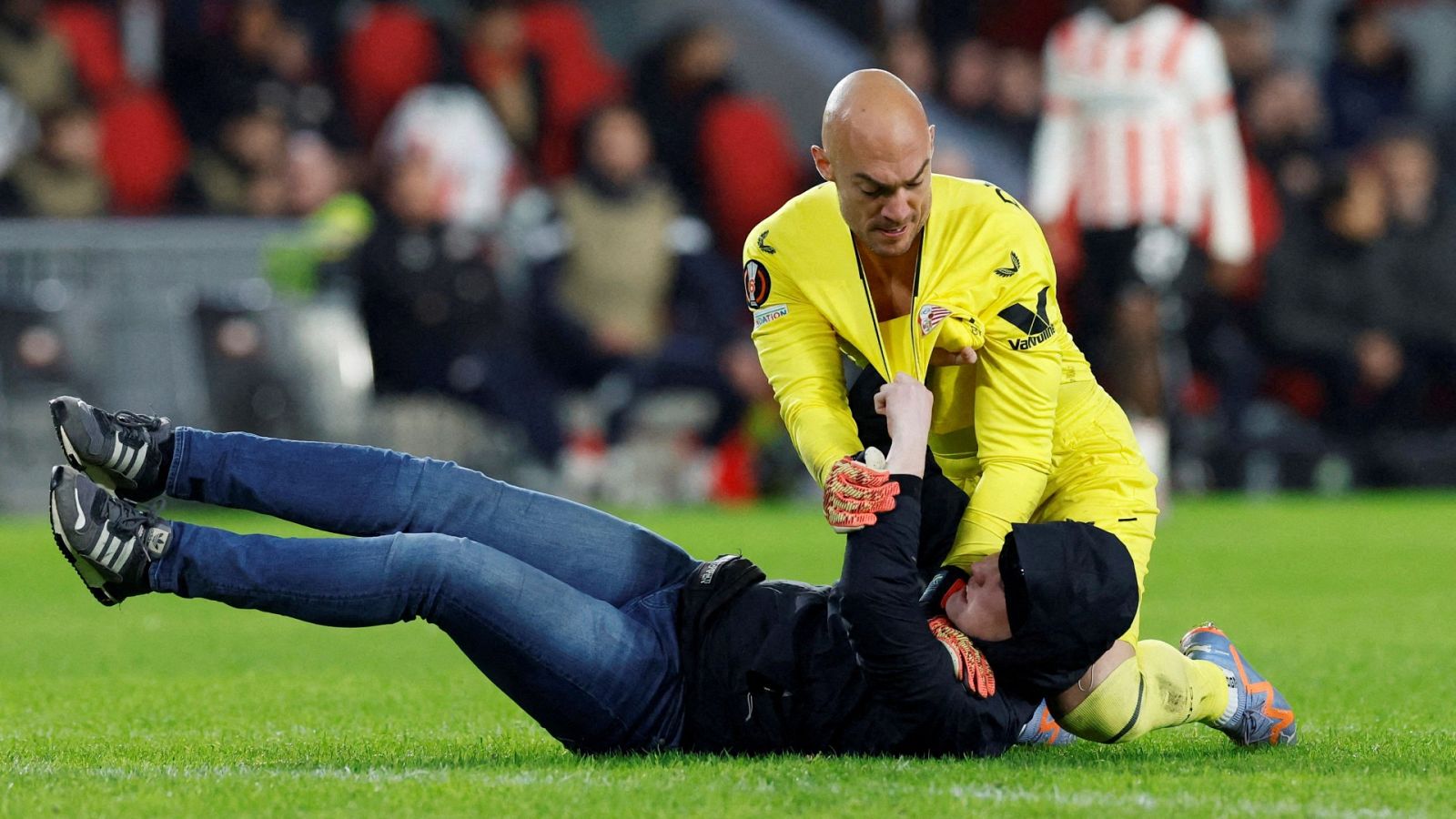 Un espectador salta al campo y agrede a Dmitrovic en el PSV - Sevilla | Ver