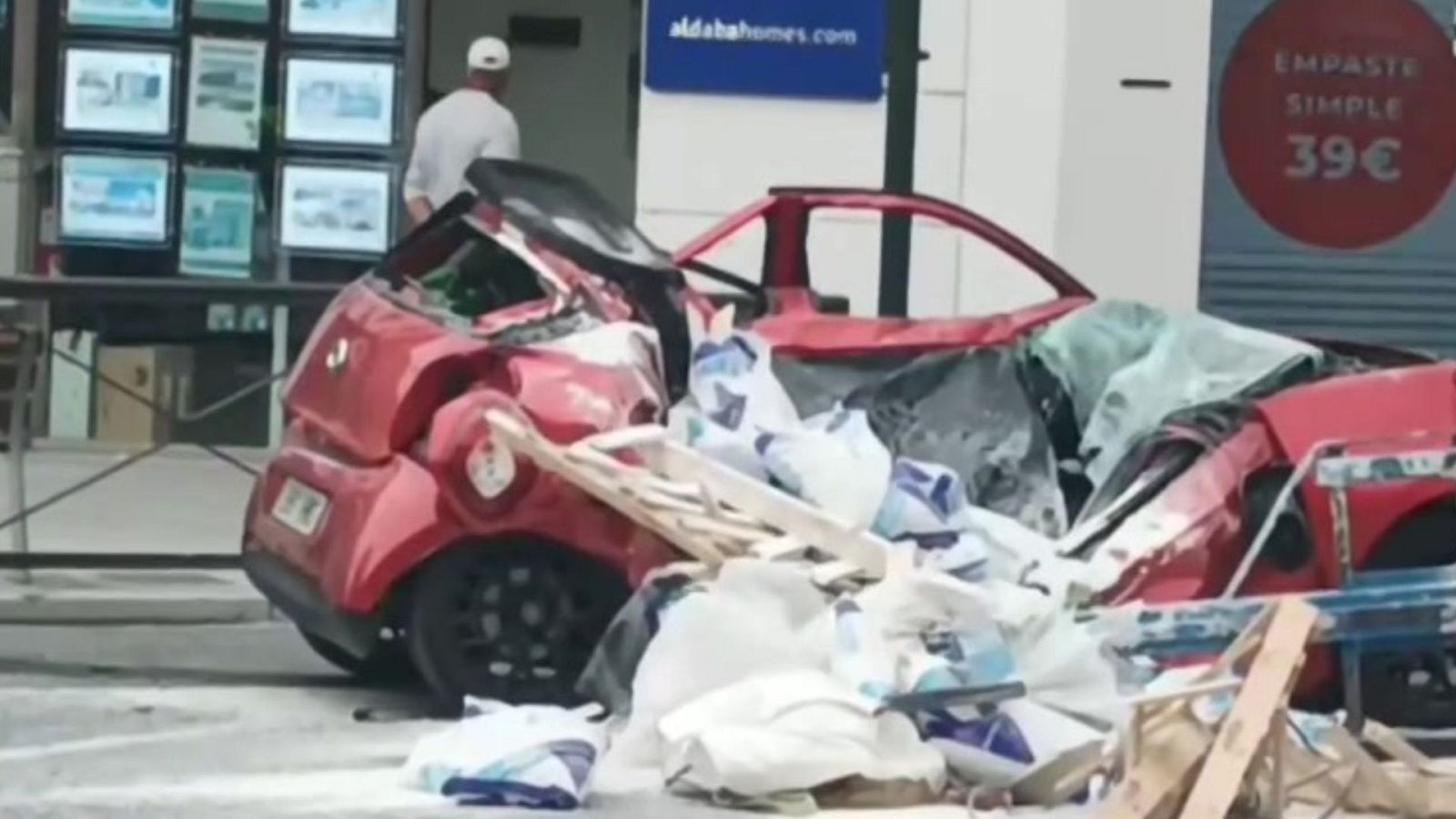 Un palé que pendía de una grúa cae sobre un coche en Granada, la conductora sale prácticamente ilesa - ver ahora